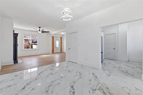 a view of an empty room with window and wooden floor