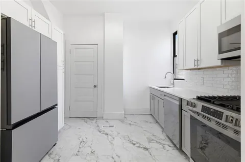 a kitchen with stainless steel appliances granite countertop a stove microwave and sink