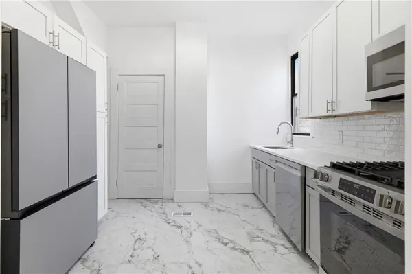 a kitchen with stainless steel appliances granite countertop a stove microwave and sink
