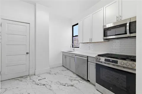a kitchen with stainless steel appliances granite countertop a refrigerator and a stove top oven