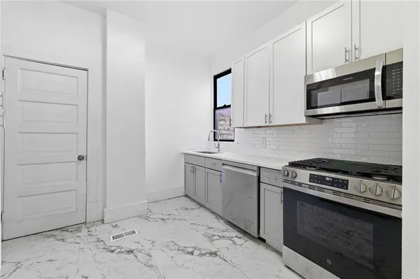a kitchen with stainless steel appliances granite countertop a refrigerator and a stove top oven