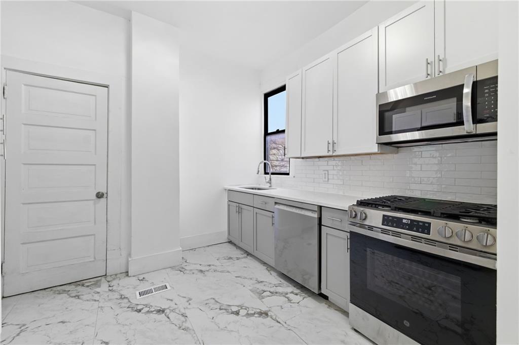 3707 Atkins Street Pittsburgh, PA 15212 - Photo 15 of 41 a kitchen with stainless steel appliances granite countertop a stove microwave and sink