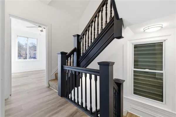a view of a room with wooden floor and ceiling fan