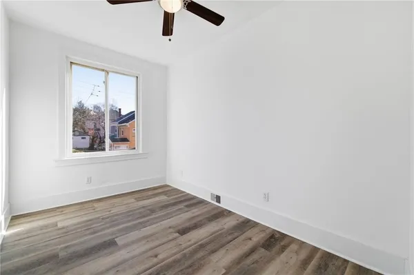 an empty room with a ceiling fan and window