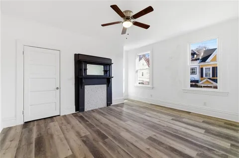 a view of empty room with wooden floor and ceiling fan