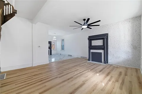 a view of a livingroom with a ceiling fan and wooden floor