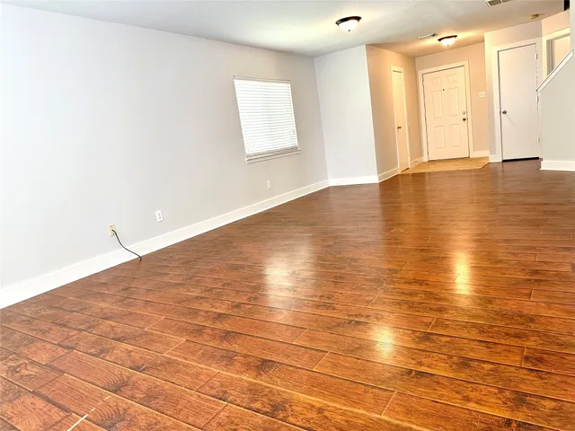 a view of an empty room with wooden floor