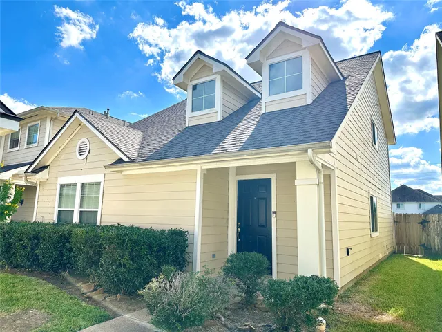 a view of a white house next to a yard