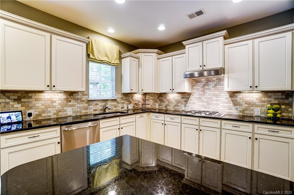692 Old Cove Road Tega Cay, SC 29708 - Photo 15 of 44 a kitchen with granite countertop white cabinets white appliances a sink and a window