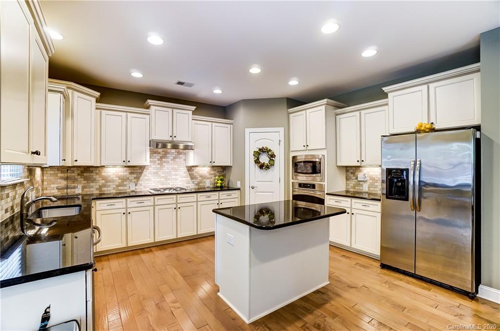 692 Old Cove Road Tega Cay, SC 29708 - Photo 16 of 44 a kitchen with kitchen island a counter top space cabinets and stainless steel appliances