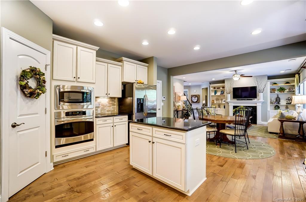 692 Old Cove Road Tega Cay, SC 29708 - Photo 17 of 44 a kitchen with stainless steel appliances granite countertop a stove top oven a sink dishwasher a refrigerator and white cabinets with wooden floor