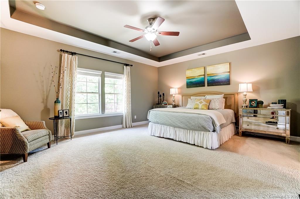 692 Old Cove Road Tega Cay, SC 29708 - Photo 23 of 44 a bedroom with bed and a chandelier