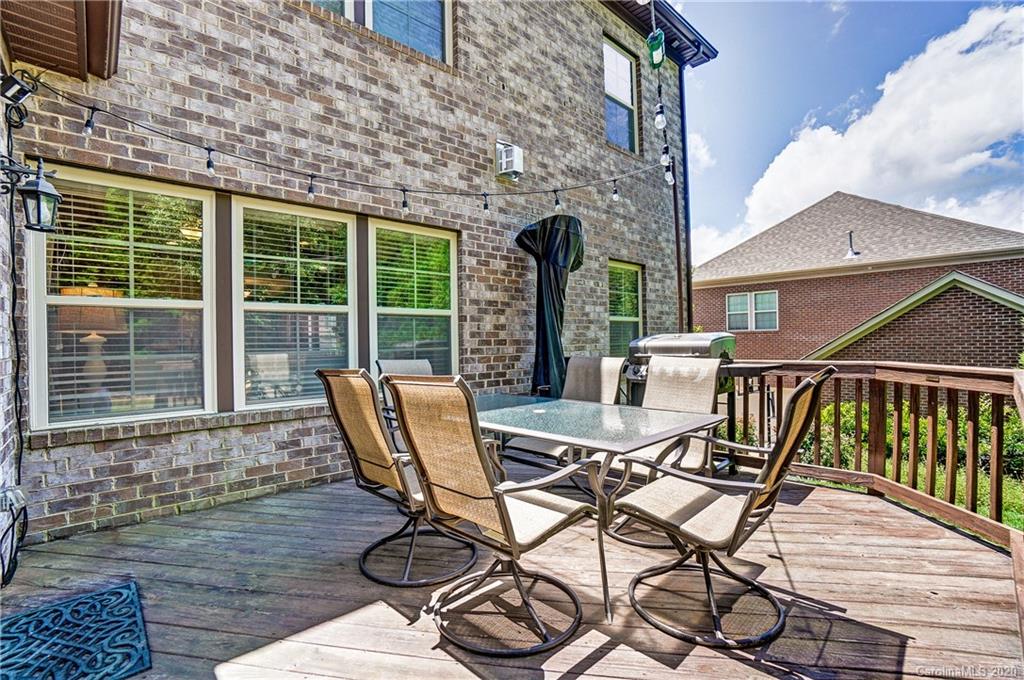 692 Old Cove Road Tega Cay, SC 29708 - Photo 36 of 44 a view of a patio with table and chairs with wooden floor and fence