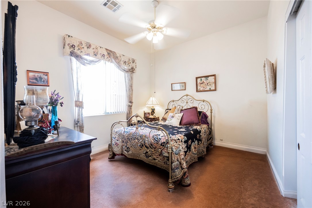5494 Pine Ranch Street Las Vegas, NV 89113 - Photo 43 of 54 A well-lit bedroom features a ceiling fan, plush carpet, and a sizable window for natural light.