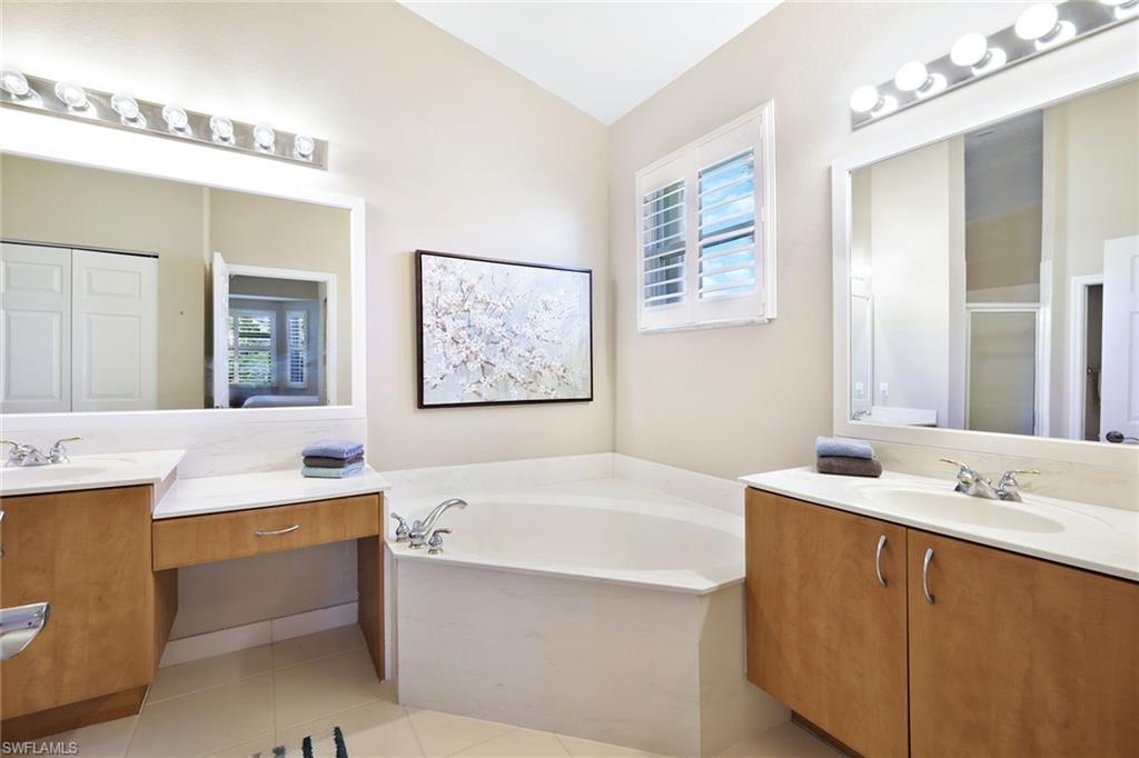 9354 Springview Loop Estero, FL 33928 - Photo 17 of 30 a bathroom with a tub a sink and mirror