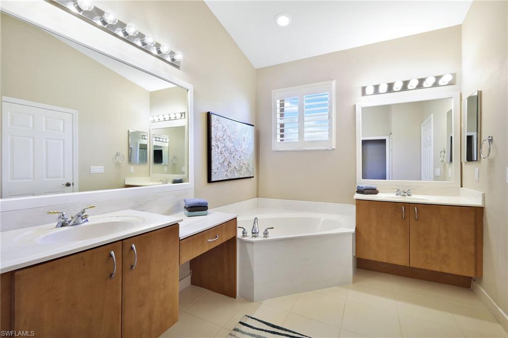9354 Springview Loop Estero, FL 33928 - Photo 18 of 30 a bathroom with a sink double vanity granite tub and a mirror