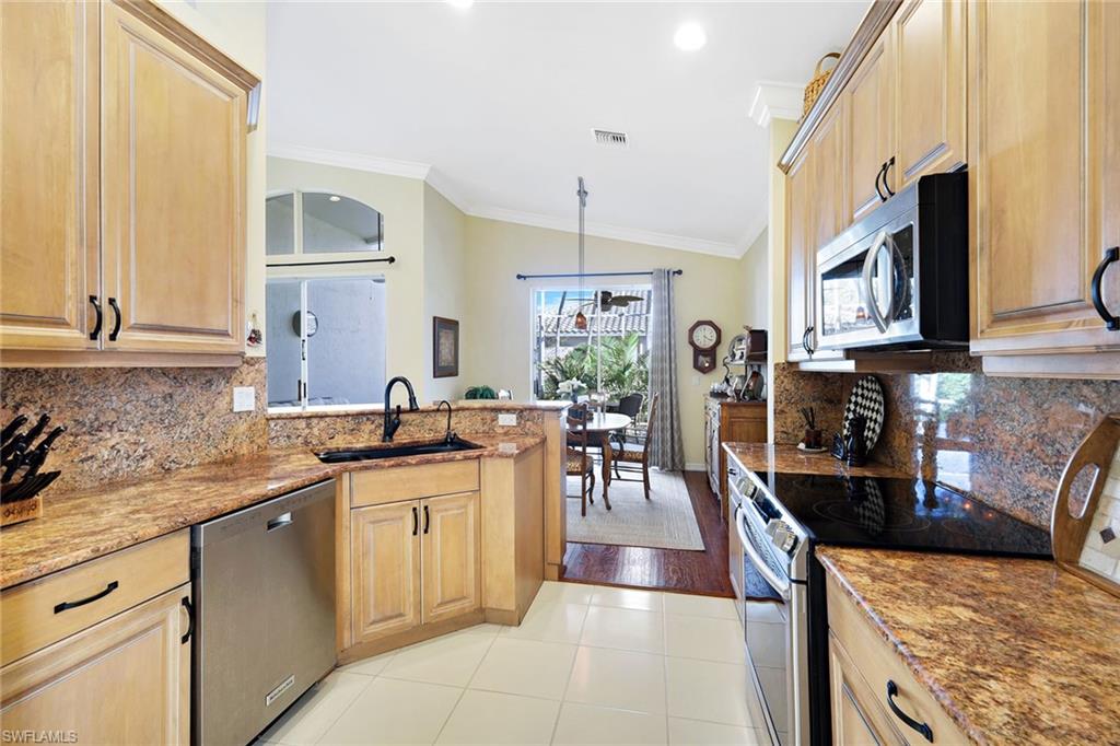 9354 Springview Loop Estero, FL 33928 - Photo 7 of 30 a kitchen with stainless steel appliances granite countertop a sink stove and cabinets