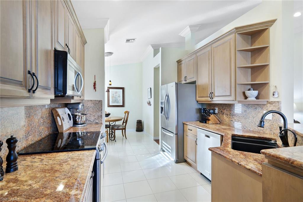 9354 Springview Loop Estero, FL 33928 - Photo 8 of 30 a kitchen with stainless steel appliances kitchen island granite countertop a sink stove and cabinets