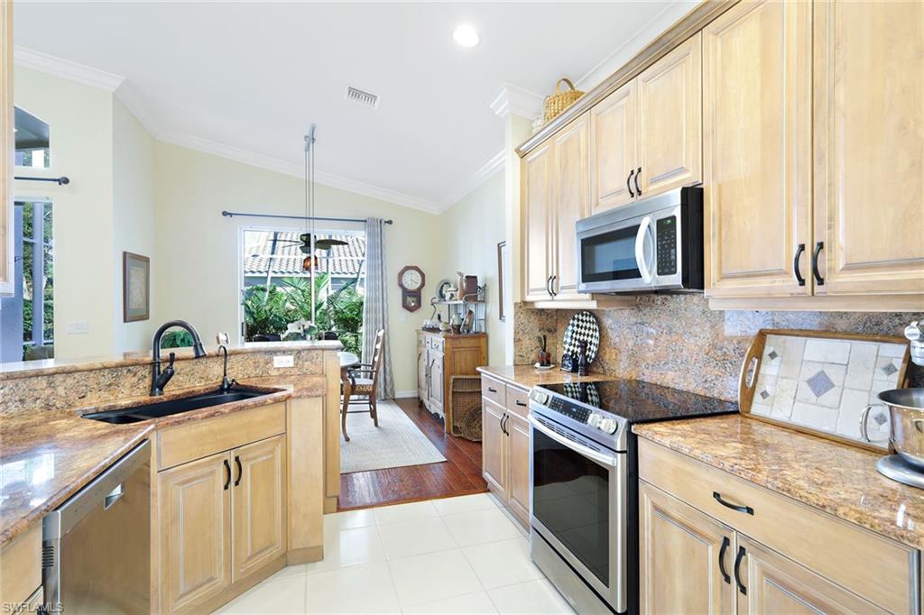 9354 Springview Loop Estero, FL 33928 - Photo 10 of 30 a kitchen with stainless steel appliances granite countertop a sink stove and microwave
