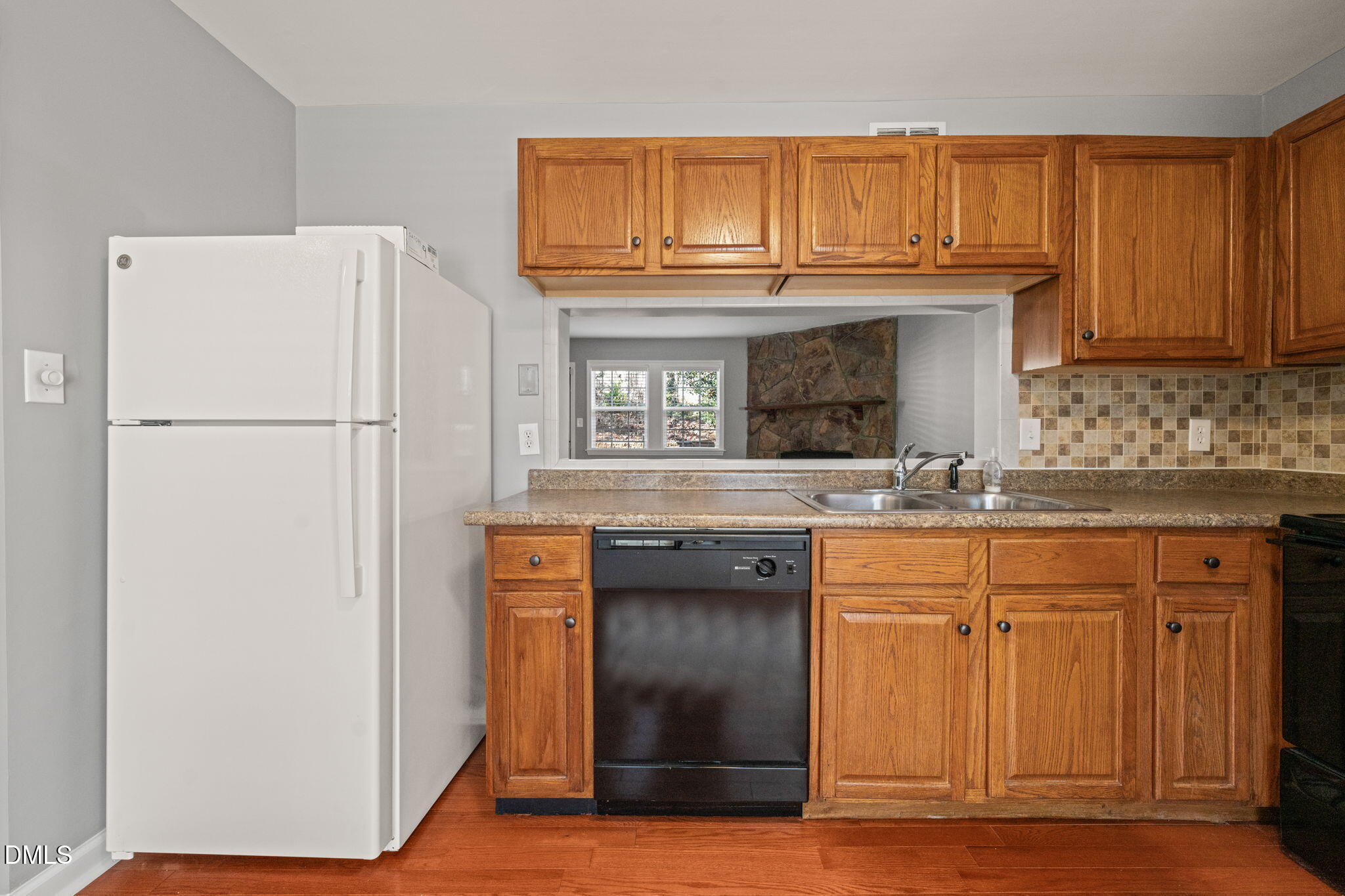 7739 Ohmann Court Raleigh, NC 27615 - Photo 11 of 38 a kitchen with granite countertop a refrigerator a sink and a stove
