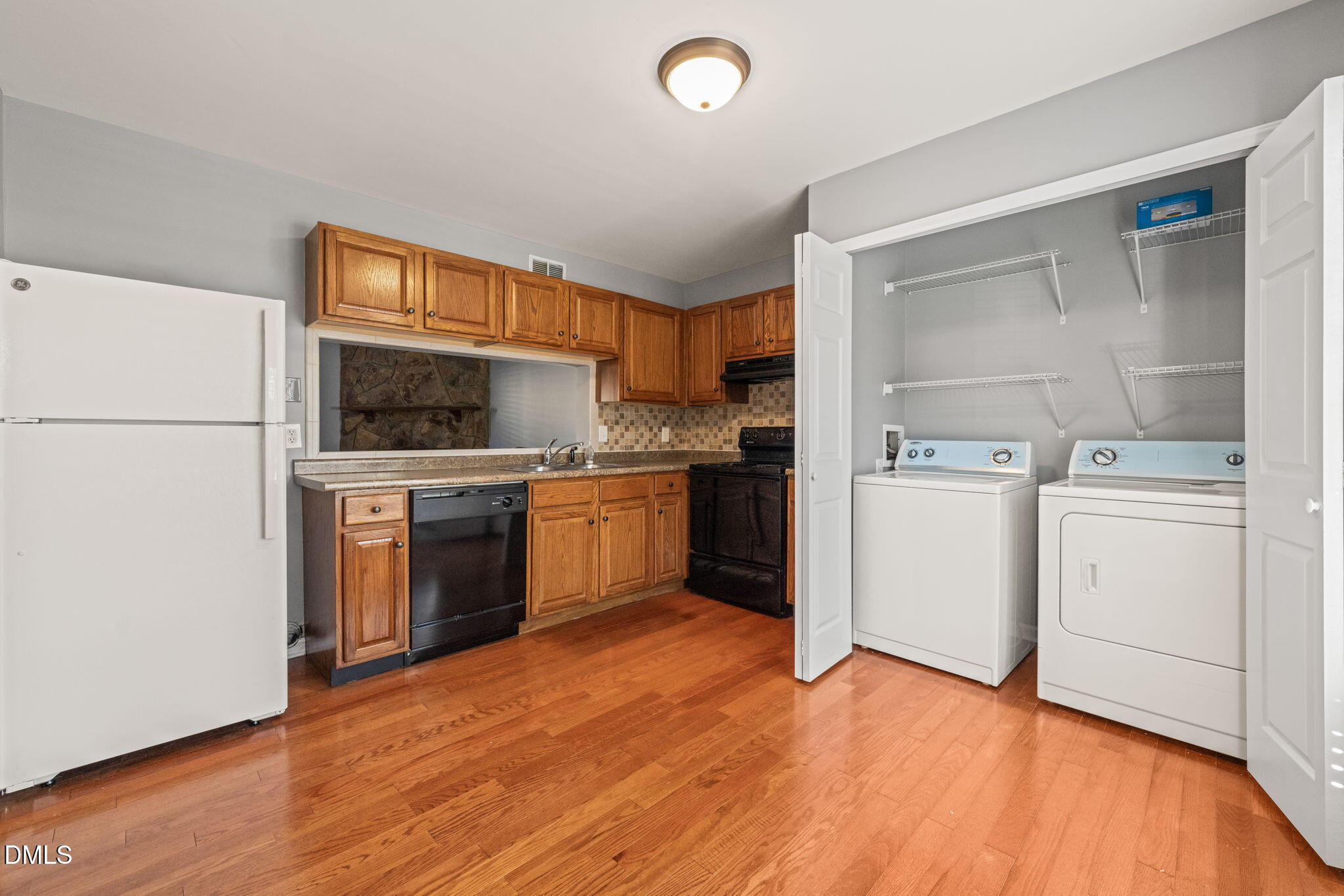 7739 Ohmann Court Raleigh, NC 27615 - Photo 13 of 38 a kitchen with a stove top oven sink and cabinets