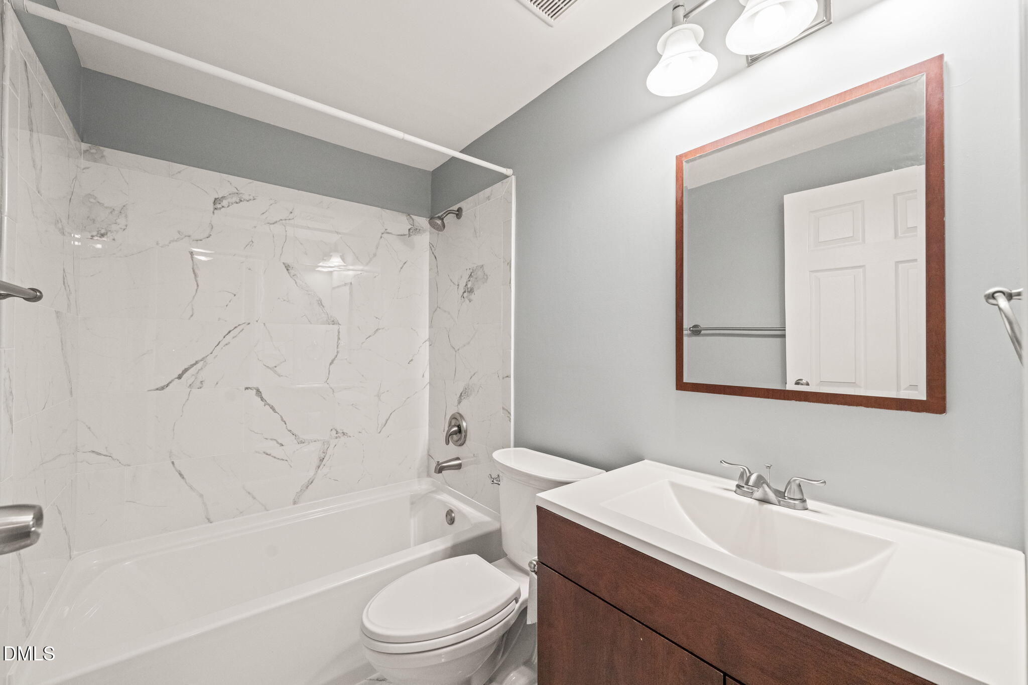 7739 Ohmann Court Raleigh, NC 27615 - Photo 20 of 38 a bathroom with a toilet a sink a mirror a bathtub and vanity