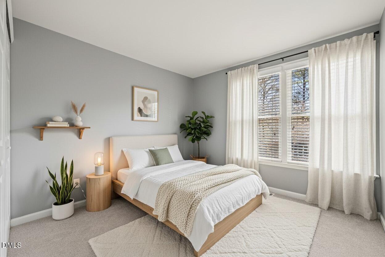 7739 Ohmann Court Raleigh, NC 27615 - Photo 24 of 38 a bedroom with a bed and a potted plant