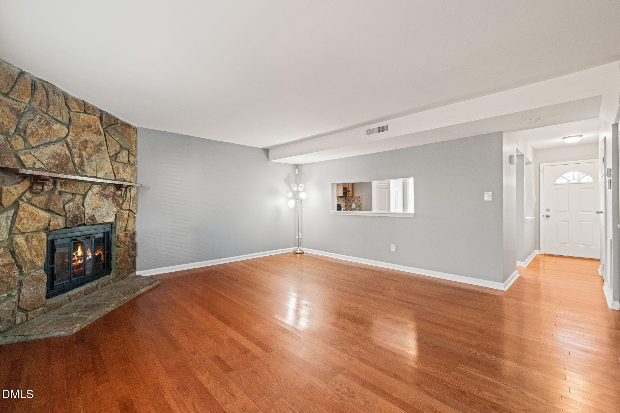 7739 Ohmann Court Raleigh, NC 27615 - Photo 5 of 38 a view of an empty room with wooden floor and a fireplace