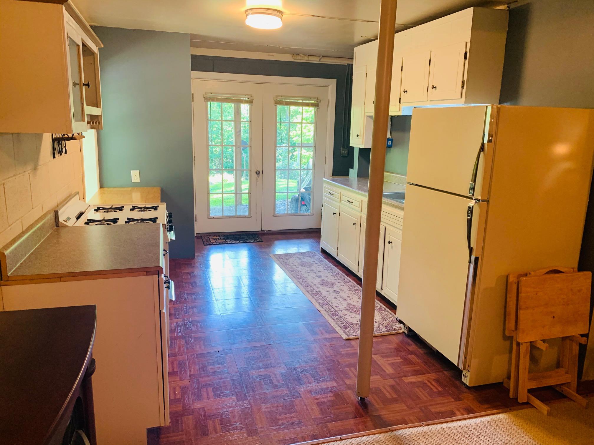 832 Old Henry Road Henry, VA 24102 - Photo 22 of 30 a view of a kitchen with wooden floor and a refrigerator
