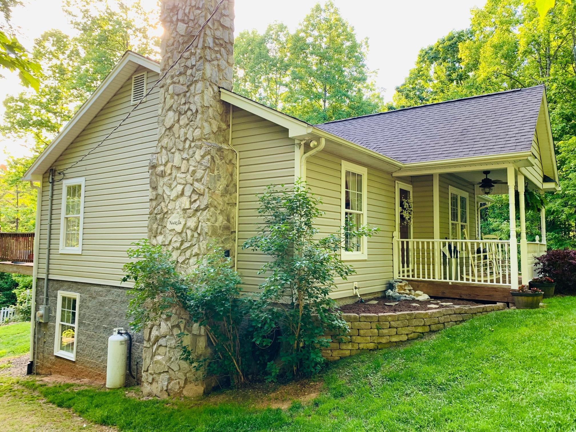 832 Old Henry Road Henry, VA 24102 - Photo 5 of 30 a front view of a house with a garden and yard