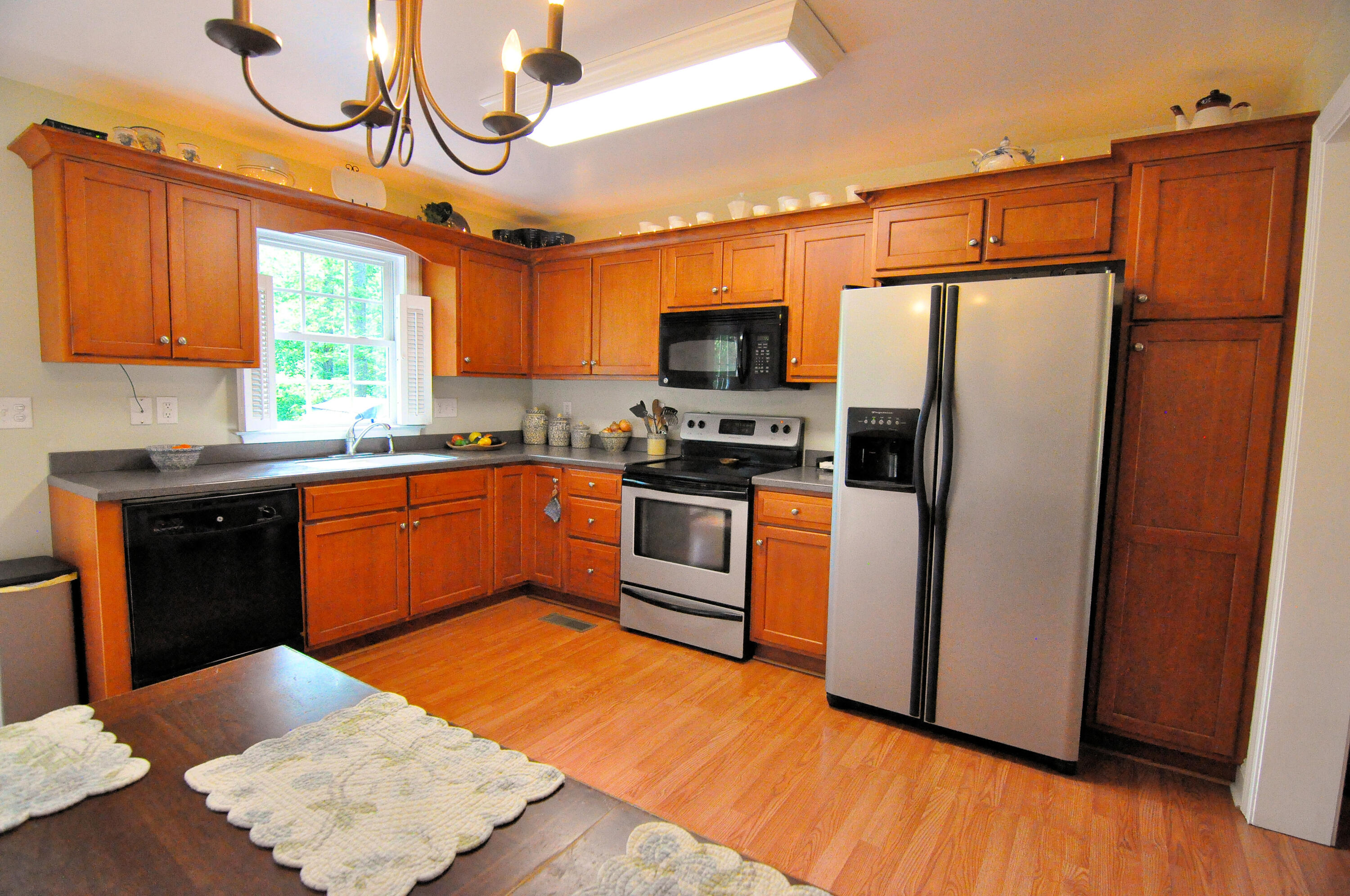 832 Old Henry Road Henry, VA 24102 - Photo 10 of 30 a kitchen with stainless steel appliances granite countertop a refrigerator a sink a stove a microwave and wooden floors