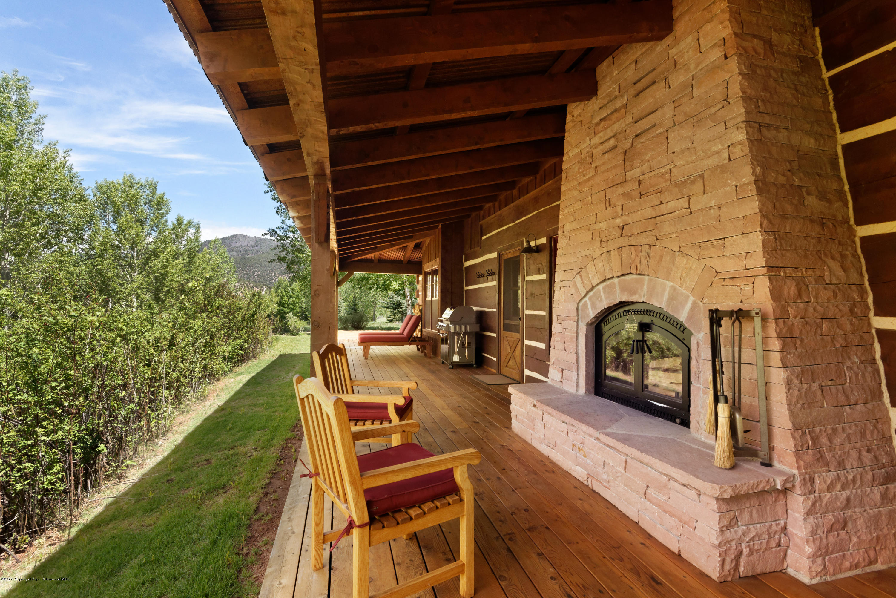 12 Arbaney Ranch Road Basalt, CO 81621 - Photo 3 of 22 a view of a patio with couches chairs and a fireplace with wooden floor