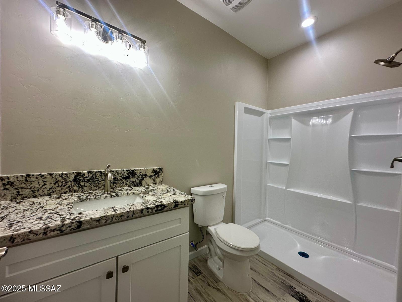 1845 Gardenias Court Rio Rico, AZ 85648 - Photo 14 of 19 a bathroom with a granite countertop sink a toilet and shower