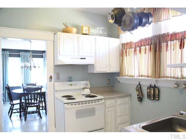 2613 Banks Road Raleigh, NC 27603 - Photo 4 of 12 a kitchen with stainless steel appliances granite countertop a stove a sink a dining table and chairs with wooden floor