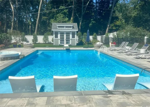 a view of a house with pool and chairs