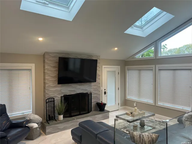 a living room with furniture a fireplace and a flat screen tv