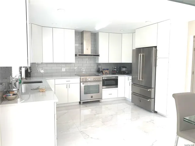 a kitchen with stainless steel appliances a refrigerator sink and cabinets