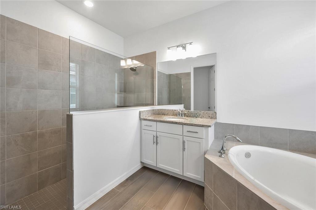 43240 Boardwalk Loop Punta Gorda, FL 33982 - Photo 24 of 41 a bathroom with a tub a sink and mirror