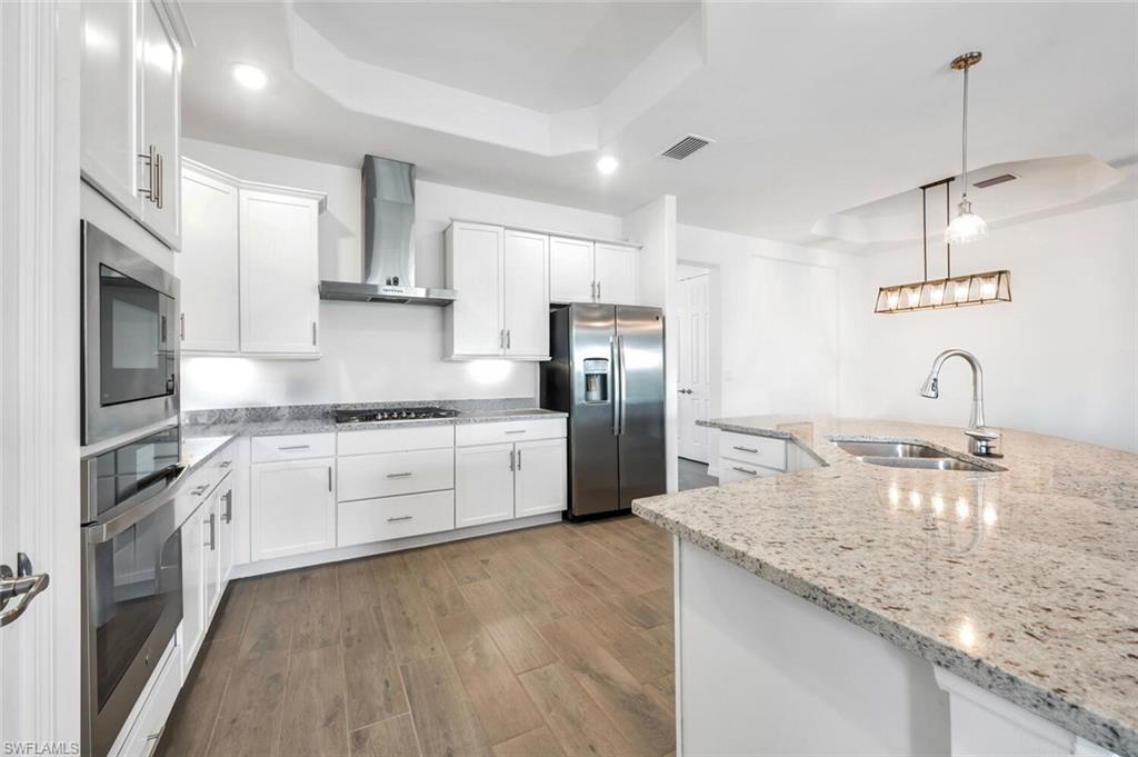 43240 Boardwalk Loop Punta Gorda, FL 33982 - Photo 7 of 41 a kitchen with stainless steel appliances granite countertop a sink a stove and a refrigerator