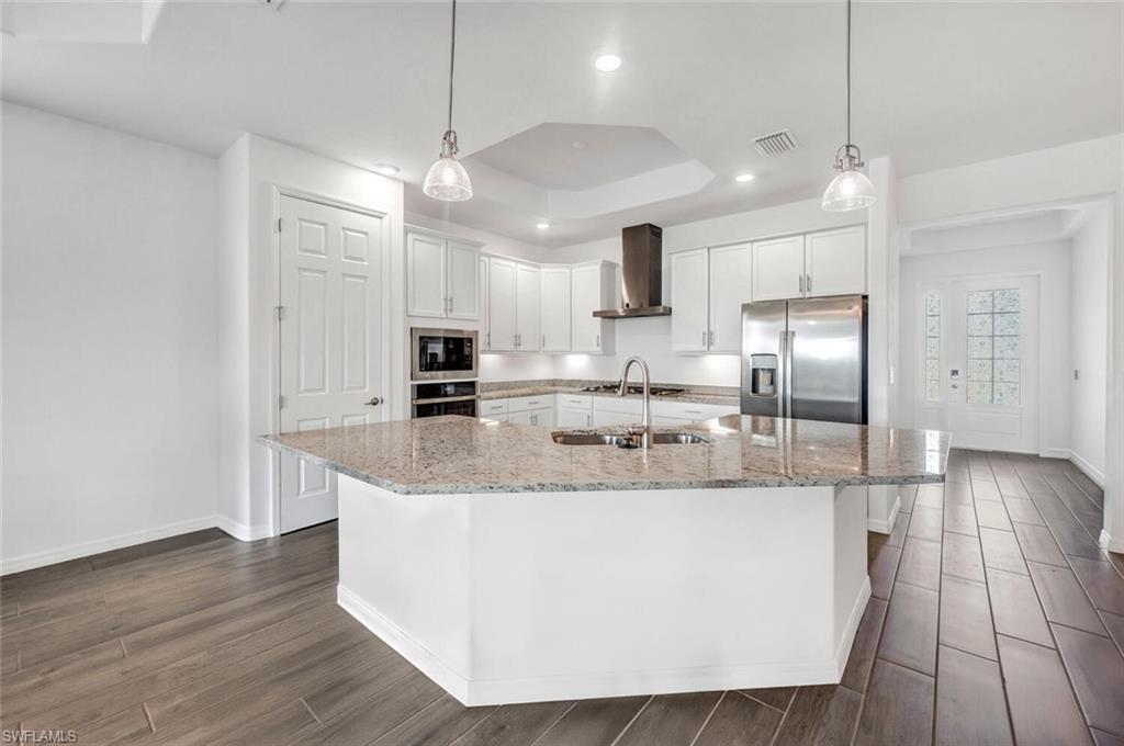 43240 Boardwalk Loop Punta Gorda, FL 33982 - Photo 9 of 41 a large kitchen with kitchen island a large counter space a sink appliances and cabinets