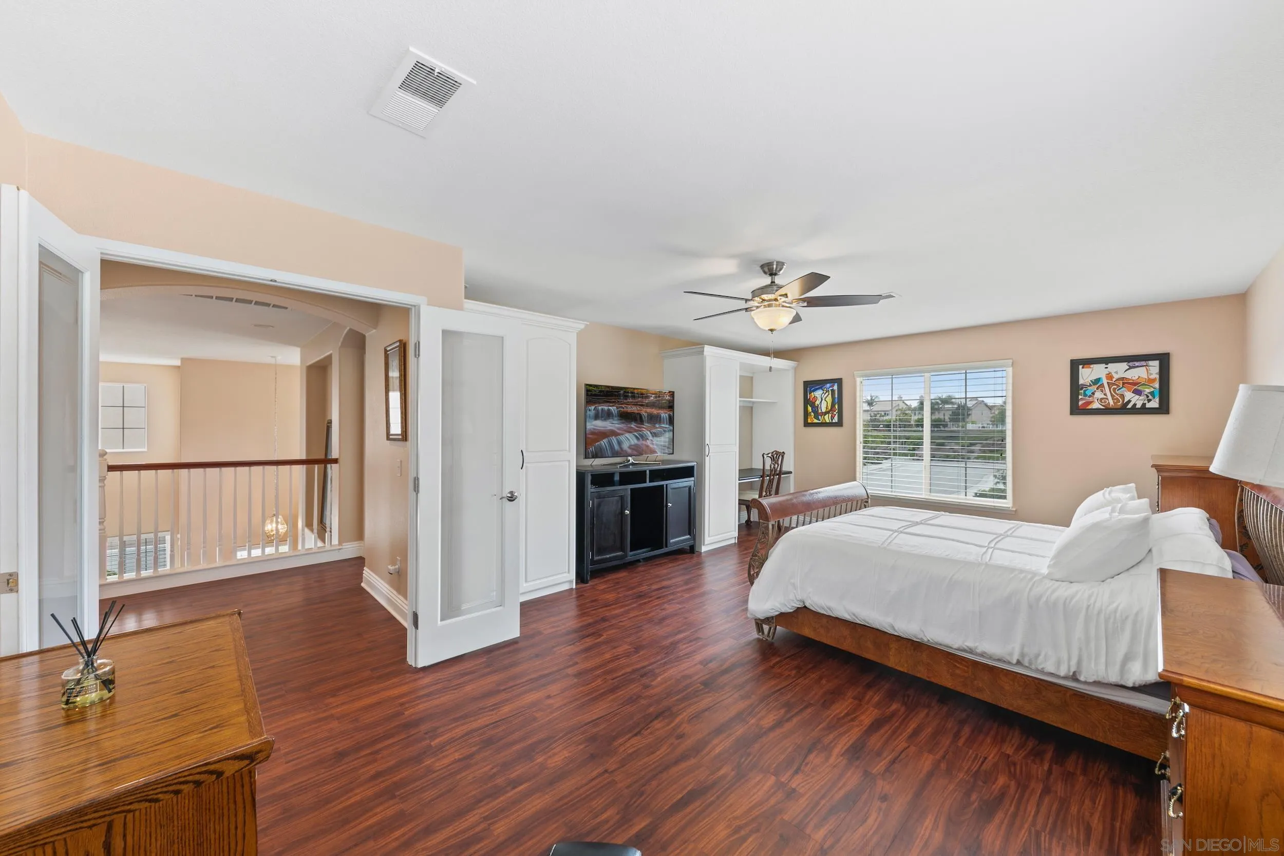 35920 Devonshire Lane Wildomar, CA 92595 - Photo 39 of 50 a spacious bedroom with a bed and a large window with wooden floor