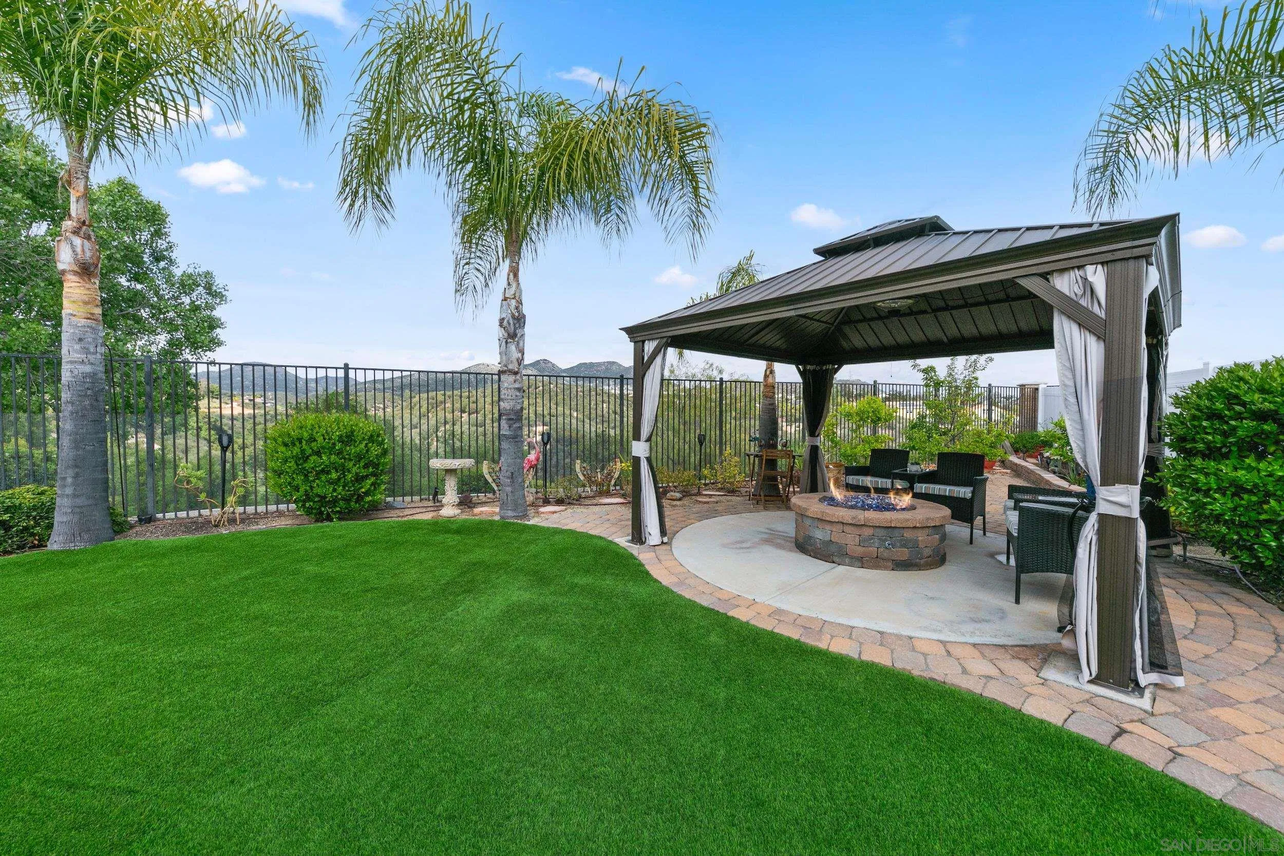 35920 Devonshire Lane Wildomar, CA 92595 - Photo 49 of 50 a view of a patio with table and chairs potted plants and palm trees