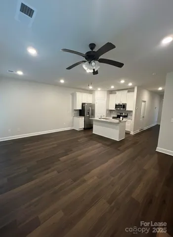 a view of kitchen with stainless steel appliances kitchen island in center
