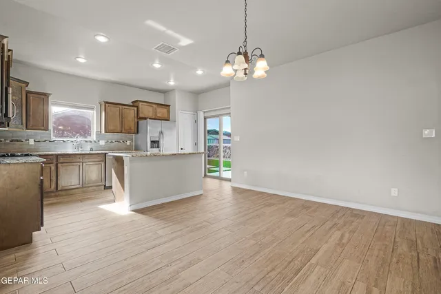 a view of a kitchen with a sink wooden cabinets and stainless steel appliances