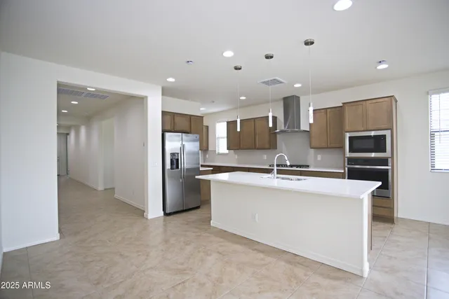 a kitchen with stainless steel appliances a sink stove and refrigerator