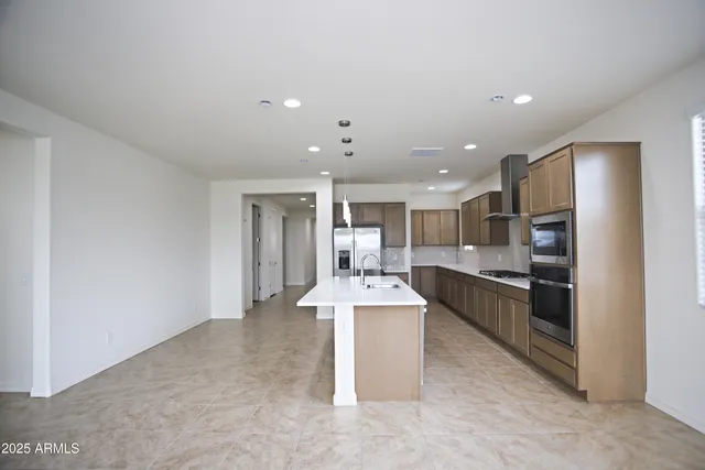 a kitchen with stainless steel appliances granite countertop a refrigerator and a stove