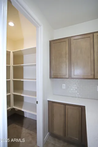 an empty room with kitchen view and a window