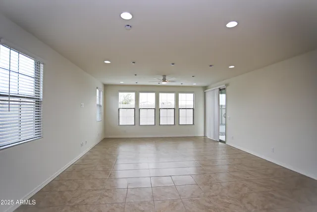 a view of a big room with a ceiling fan and kitchen view