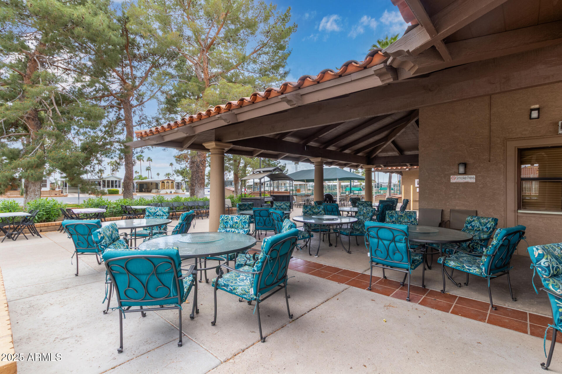 111 South Greenfield Road, Unit 449 Mesa, AZ 85206 - Photo 28 of 34 a view of a patio with a dining table and chairs with a small yard