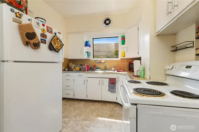 a kitchen with white cabinets and white appliances